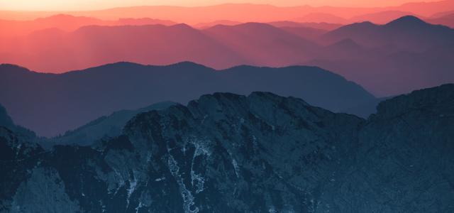 An image of a sunrise over a range of mountains